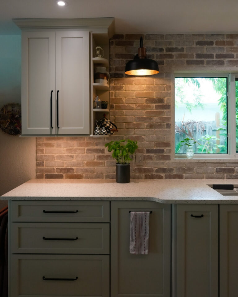 sage shaker cabinets brick backsplash